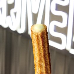 Pizza Patrón - Crispy Churro filled with Bavarian Cream gently rolled in a cinnamon and sugar blend.