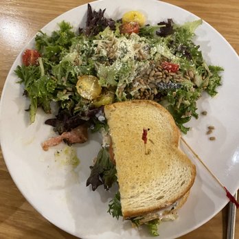 Prairie Canary Restaurant & Bar - Pesto chicken club sandwich (only half is pictured) with salad - Burgers Near Me - Grinnell, Iowa