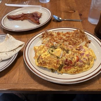 Copper Canyon Cafe - A breakfast plate with an omelet, hash browns, and tortillas, accompanied by a cup of coffee and water at Copper Canyon Cafe. - Mexican Near Me - Albuquerque, New Mexico