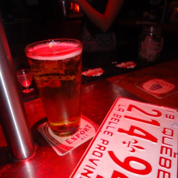 Chez Serge - a pint of beer next to a license plate - Sports Bars Near Me - Montreal, Quebec