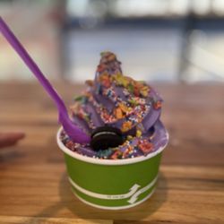 Kem Kem - Ube soft serve in cup topped with fruity pebbles, sprinkles, and Oreo.