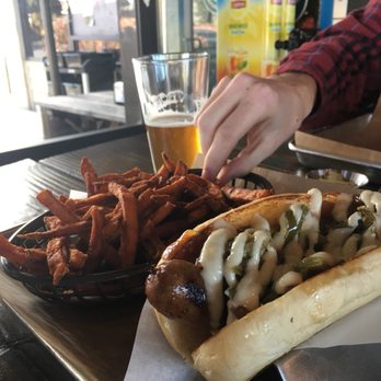 Bangers & Brews - Westside - Deschutes Pine Drop IPA Brat (carmrlized onions, sweet peppers and garlic aioli) and sweet potato fries. So happy! - German Near Me - Bend, Oregon