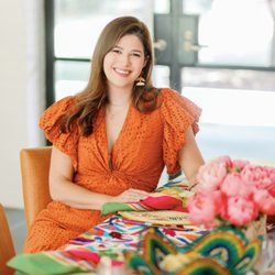 Bethany Michaela Studio - Photo of a woman in an orange dress sitting at a table