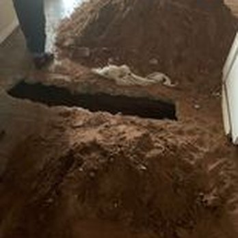 Joe Rushing - A mound of dirt or soil is shown with a black rectangular object partially buried in it, possibly in an indoor setting. - Plumbing Near Me - Lubbock, Texas