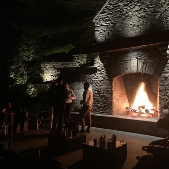 Inn at Taughannock Falls - The dry stacked stone patio fireplace, adjacent to the well-stocked outdoor bar - Hotels Near Me - Trumansburg, New York
