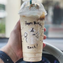 a hand holding a cup of iced coffee a hand holding a cup of iced coffee