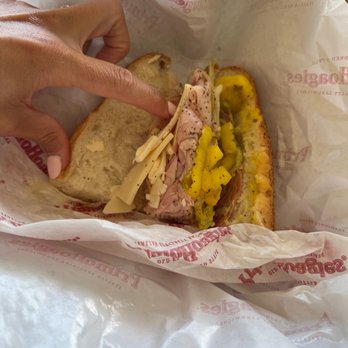 PrimoHoagies - a person holding a sandwich in a wrapper - Sandwiches Near Me - Wildwood Crest, New Jersey