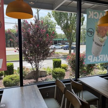 McDonald's - Inside a restaurant, looking out through large glass windows at a parking lot with cars, trees, and flowering bushes. - Fast Food Near Me - Lima, Pennsylvania
