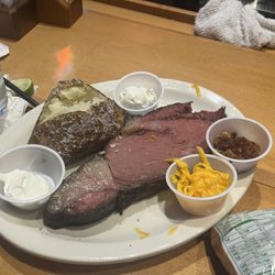 Texas Roadhouse - 12 ounce prime rib with a load of baked potato on the side