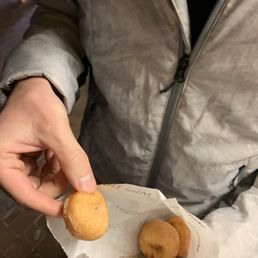 a person holding a bag of donuts