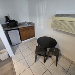 Super 8 by Wyndham Monterey - Coffee, fridge, wet-bar sink, mini table & chair set up and wall mounted air unit.