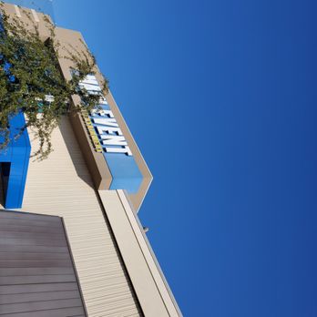 Main Event Gilbert - a tall building with a blue sign - A Walmart store exterior with a prominent sign and modern architecture, set against a bright blue sky. - Bowling Near Me - Gilbert, Arizona