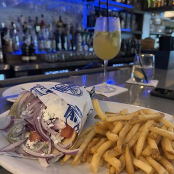 Taverna Opa - Chicken gyro wrap with fries and white sangria pictured in the back - Greek Near Me - Hollywood, Florida