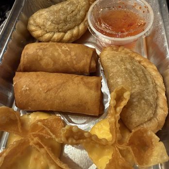 Monkey Thai Diner - Appetizer for 2; crab Rangoon's, veg. spring rolls, puff pastry, dipping sauce. - A tray of Asian appetizers featuring spring rolls, crab Rangoon, fried pastries, and a container of dipping sauce. - Thai Near Me - Clark, New Jersey