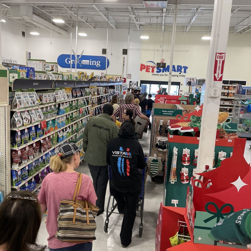 Long line of people waiting to be checked out with only one cashier on the register at 12 o'clock on a Saturday Long line of people waiting to be checked out with only one cashier on the register at 12 o'clock on a Saturday