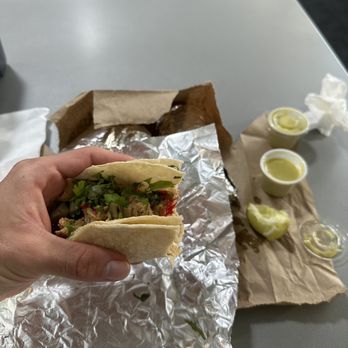 Pollo Caliente - Chicken taco on corn tortilla containing cilantros, onions, and peppers with verde sauce and lime on the side - Mexican Near Me - Austin, Texas