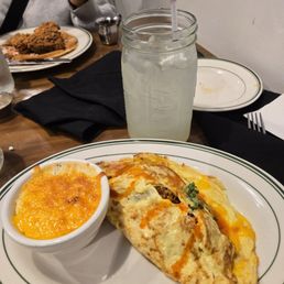Cheddar grits, fried chicken omelet and a lemonade. Chicken & waffles in the background