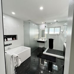 Our bathroom renovation offers privacy through a frosted glass enclosure, complemented by a contemporary freestanding tub.