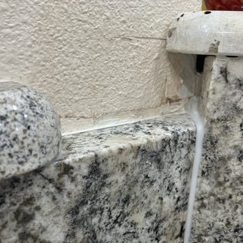 FLOFORM Countertops - This photo shows they did not cut the granite long enough and filled it with a whole bunch of caulking. - Countertop Installation Near Me - Auburn, Washington