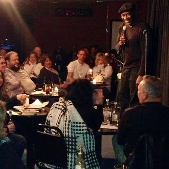 Funny Farm Comedy Club - a man standing on a stage speaking into a microphone - Comedy Clubs Near Me - Youngstown, Ohio Funny Farm Comedy Club - a man standing on a stage speaking into a microphone - Comedy Clubs Near Me - Youngstown, Ohio