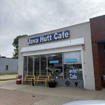 Java Hutt - Java Hutt Cafe's exterior features large glass windows, yellow benches, and potted plants, with signs indicating coffee and breakfast offerings. - Coffee & Tea Near Me - Hazel Park, Michigan