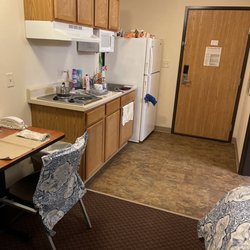 Value Place - Kitchen at area has a two burner electric stove and a fridge.
