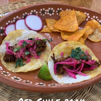Gobble This - A plate of two Red Chile Pork Tacos topped with pickled onions and cilantro, served with tortilla chips, radish slices, and a lime wedge. - Salvadoran Near Me - Albuquerque, New Mexico
