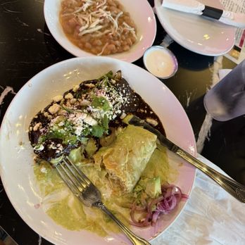 Kulturas - Mole enchilada on the left and chicken verde on the right with a side of beans. - Latin American Near Me - Ontario, California Kulturas - Mole enchilada on the left and chicken verde on the right with a side of beans. - Latin American Near Me - Ontario, California
