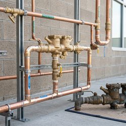 Mike Seeders Plumbing - Professionally installed copper plumbing system featuring valves, fittings, and backflow prevention equipment, demonstrating ...