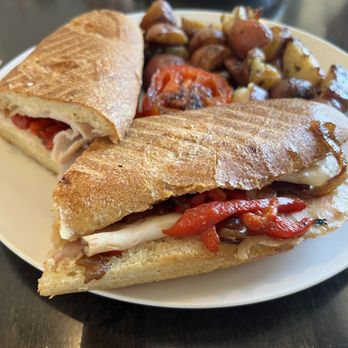 Versailles Cafe and Pastries - Cannes Panini! It has turkey, caramelized onions, sautéed bell pepper, aioli, and mozzarella cheese. With a side of potatoes - Patisserie/Cake Shop Near Me - Encinitas, California Versailles Cafe and Pastries - Cannes Panini! It has turkey, caramelized onions, sautéed bell pepper, aioli, and mozzarella cheese. With a side of potatoes - Patisserie/Cake Shop Near Me - Encinitas, California
