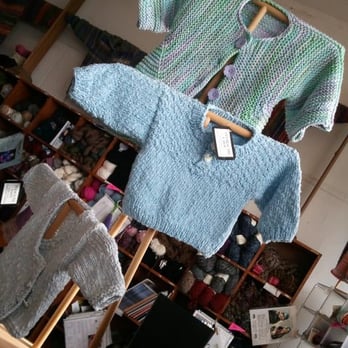 Mass Ave Knit Shop - A few of the pattern sample sweaters on display... each has a tag listing what pattern and yarn was used. - Arts & Crafts Near Me - Indianapolis, Indiana