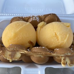 Bubble waffle in a foam clamshell, with two large scoops of mango-flavored 'Italian ice'. Bubble waffle in a foam clamshell, with two large scoops of mango-flavored 'Italian ice'.