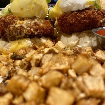 Revel - (Brunch Menu) Maryland Eggs Benedict (poached eggs, blue crab fritters, brown butter hollandaise, scallions and a MOUNTAIN of potato hash - Bars Near Me - Pittsburgh, Pennsylvania