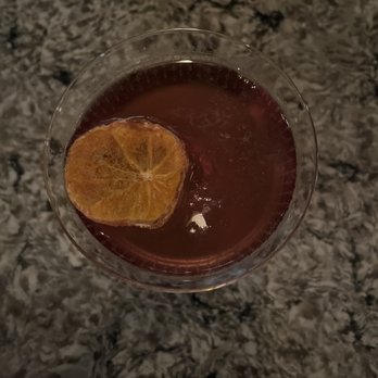 Howard & Fine - a glass of wine with a slice of orange in it - Speakeasies Near Me - Omaha, Nebraska