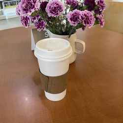 Solo Caffe - Medium chai latte infront of beautiful light and dark purple flowers