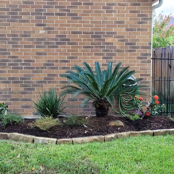 DJM Ground Services - a small garden in front of a brick house - Landscaping Near Me
