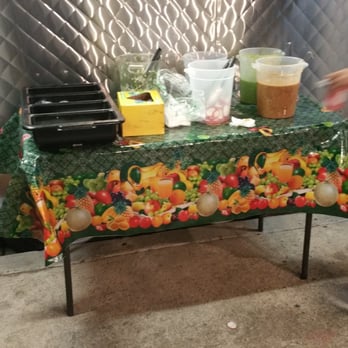 Tacos El Pimi - a person walking past a table with food on it - Food Trucks Near Me - Los Angeles, California Tacos El Pimi - a person walking past a table with food on it - Food Trucks Near Me - Los Angeles, California