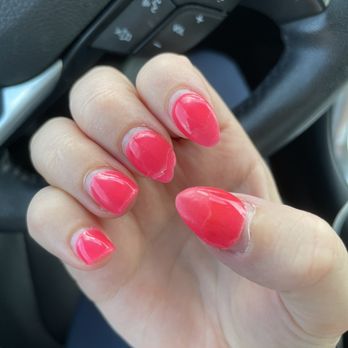 Luv Ur Nails - A person's hand with pink nail polish is held up inside a vehicle, with the steering wheel and control buttons in the background. - Nail Salons Near Me - Naperville, Illinois
