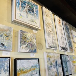 a wall full of paintings
