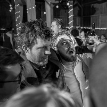 Ueda Photography - Groom exhausted during reception at the Century Barn Events in Mt. Horeb, WI. - Event Photography Near Me - Madison, Wisconsin