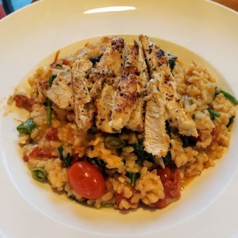 Bar La Tosca - A dish featuring seasoned rice with cherry tomatoes and chopped green onions, topped with grilled chicken slices. - Italian Near Me - Ames, Iowa