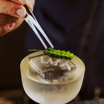 AMA Sushi - a person holding chopsticks over a cocktail - Sushi Bars Near Me - Montecito, California