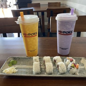 Ono Poke - Drinks and a Parrish roll - A sushi platter with six pieces and condiments is placed on a wooden table, accompanied by two large bubble tea drinks with straws inside a casual eatery. - Poke Near Me - Parrish, Florida