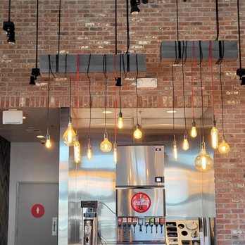 Smashburger - a brick wall with a bunch of light bulbs hanging from it - Burgers Near Me - Hollister, California