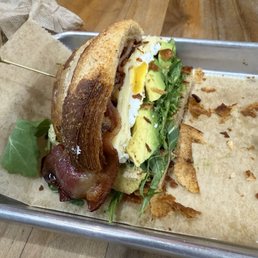 This is HALF of a breakfast croissant with thick sliced bacon, arugula, avocado, and tomato. This is HALF of a breakfast croissant with thick sliced bacon, arugula, avocado, and tomato.