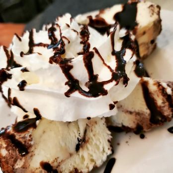 Amici Restaurant - a slice of cheesecake topped with whipped cream and chocolate sauce - Italian Near Me - Cherry Hill, New Jersey