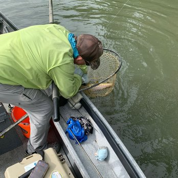 River Through Atlanta - Chris Scalley assisting a customer land a trout. - Fishing Near Me River Through Atlanta - Chris Scalley assisting a customer land a trout. - Fishing Near Me