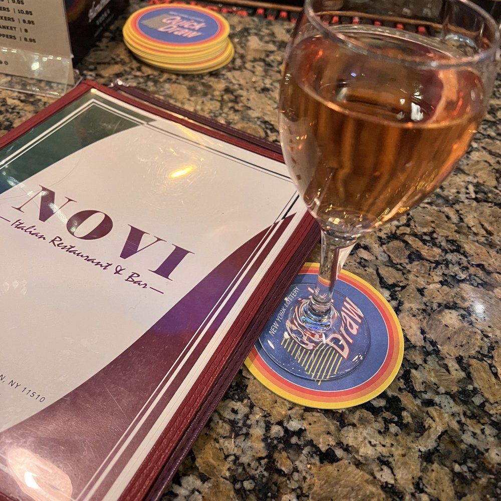 a glass of wine and a menu on a table