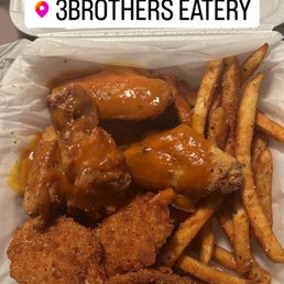 chicken wings and fries in a styrofoam container chicken wings and fries in a styrofoam container