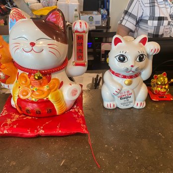 Private Kitchen - a man behind a counter with a statue of a cat - Chinese Near Me - Oklahoma City, Oklahoma